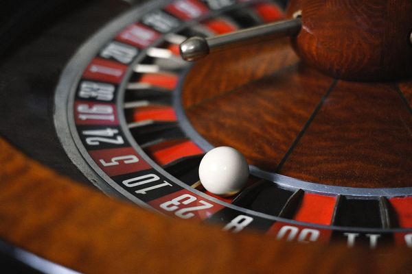 a mahogany roulette wheel with a white ball placed on the red number 23 a mahogany roulette wheel with a white ball placed on the red number 23