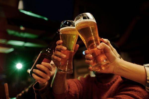 two beer glasses spilling beer