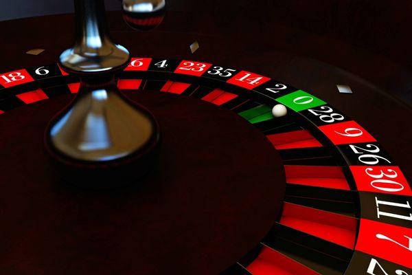 a dark roulette table with the white ball on the green pocket a dark roulette table with the white ball on the green pocket
