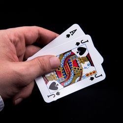 Hand holding ace an jack of spades