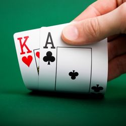 Hand folding up a king of hearts and ace of spades