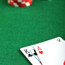 King of clubs with ace of hearts cards laying on green casino table