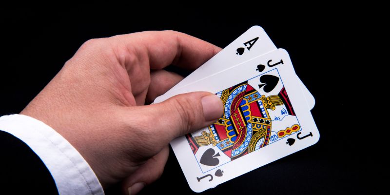 Untitled design (6) Hand holding ace and jack of spades in hand