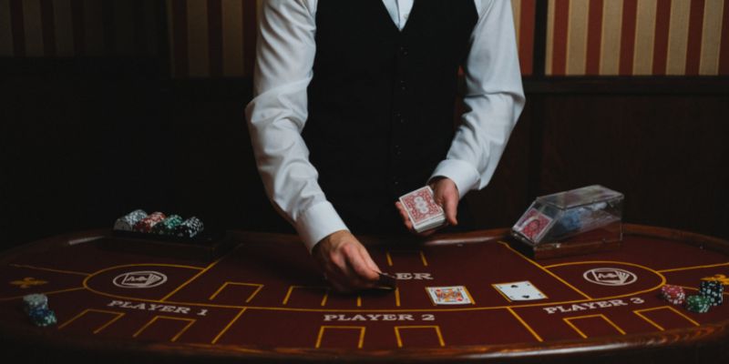 a blackjack dealer dealing cards at a blackjack table a blackjack dealer dealing cards at a blackjack table