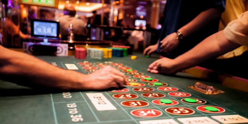 a roulette table with players placing chips a roulette table with players placing chips