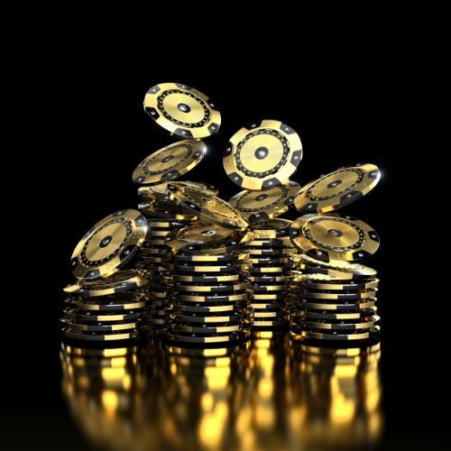 black and gold roulette chips stacked together black and gold roulette chips stacked together
