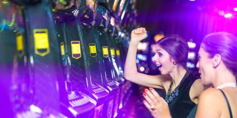 two women celebrating a win on a slot machine two women celebrating a win on a slot machine