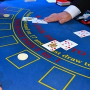 Casino table with cards and hands of dealer and player