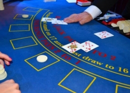 Casino table with cards and hands of dealer and player