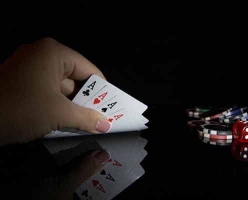 Full suite of Aces lifted by hand, with casino chips on the right