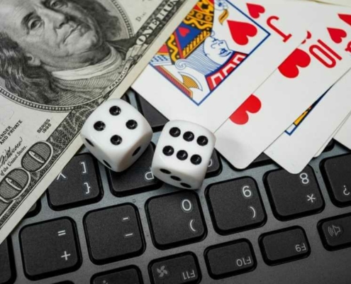 Money, dice and cards on laptop keyboard