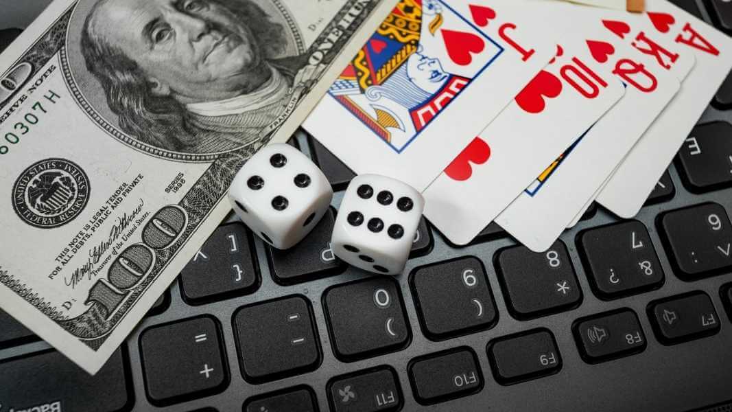 Money, dice and cards on laptop keyboard