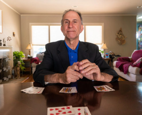 Dr. Eliot Jacobson sitting at his desk with cards