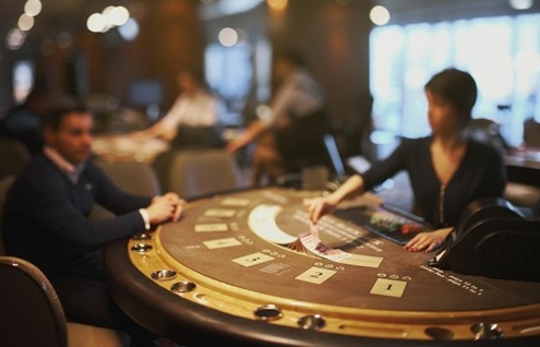 female dealer in casino dealing cards to male