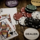 Ace and Queen of spade cards with casino chips on table