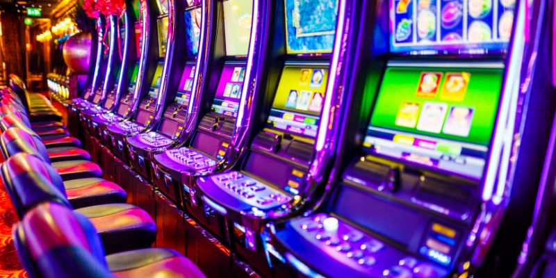 a row of brightly-lit progressive slot machines in a casino