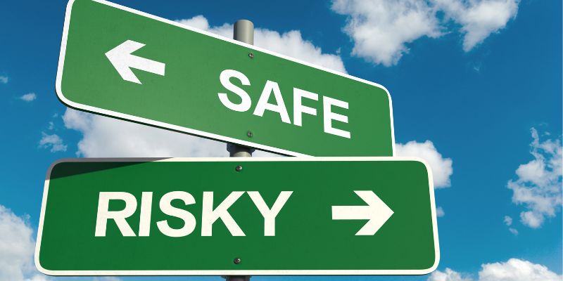 a sign post showing safe and risky directions