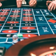 people playing at a roulette table placing bets