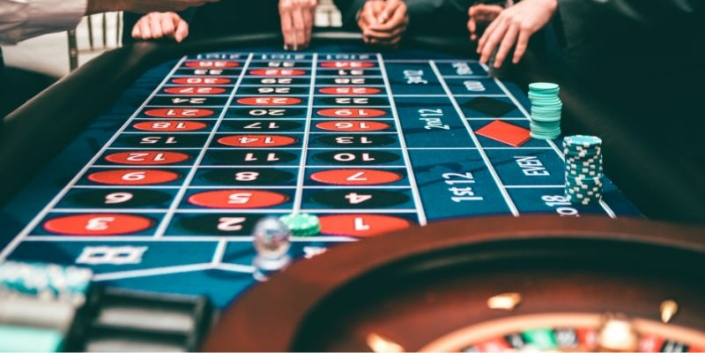 people playing at a roulette table placing bets